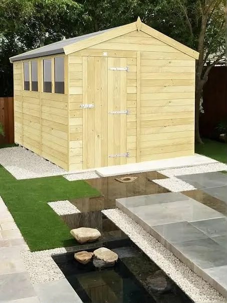 Apex timber shed with a row of windows beside a patio