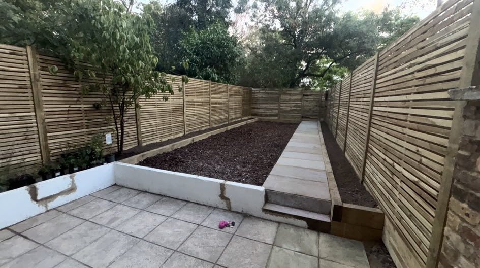Slatted fence panels round a new patio and raised bed