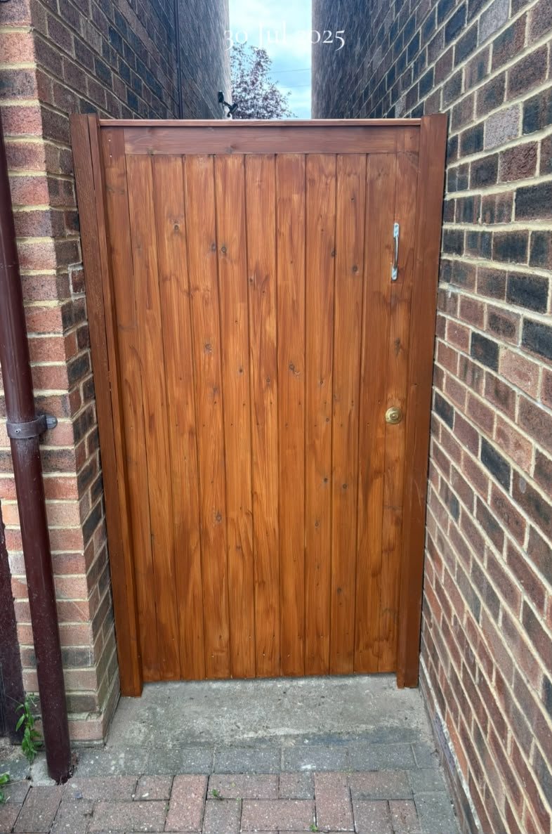 Stained timber side gate in a brick passage