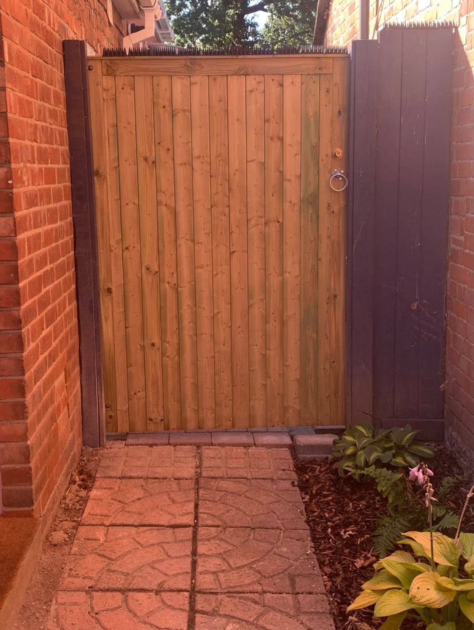 Timber side gate between red brick walls